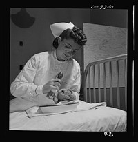 Nurse training. Care of infants is included in all nurses training. This youngster is about to get an eye irrigation. Note that nurse wears goggles for self-protection from possible infection. Sourced from the Library of Congress.