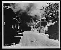 General view showing houses burning as the result of Japanese bombing raid in Bataan, the Philippine Islands. Sourced from the Library of Congress.