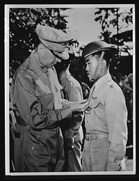 Manila, the Philippine Islands. In one of the last pictures to leave the Philippines before Manila fell to the Japs, General Douglas MacArthur (left) is shown pinning a Distinguished Service Cross on Captain Jesus A. Villamor, of the Philippine Air Force, for heroism in the air. In the center background is Lieutenant Jack Dale, of the U.S. Army Air Corps, who also received a Distinguished Service Cross. At the same time, a posthumous award of the same medal went to Captain Colin P. Kelly, Jr., who bombed and sank a Jap battleship near Luzon. Sourced from the Library of Congress.
