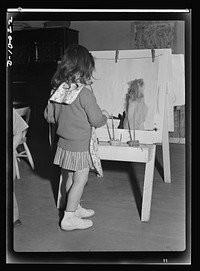 War workers' nursery. Children of war-working mothers find plenty to do in modern nursery schools. Painting with water colors is popular with young children. Sourced from the Library of Congress.