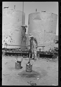 [Untitled photo, possibly related to: Pouring gasoline into tractor, large farm near Ralls, Texas. Man is day laborer] by Russell Lee