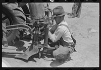 Day laborer changing plow points on four-row planter, farm near Ralls, Texas by Russell Lee