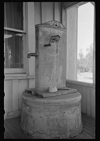 Enclosed well and chain pump on porch of ranch house near Spur, Texas by Russell Lee
