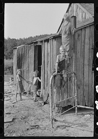 [Untitled photo, possibly related to: Son of day laborer resting on a wheel barrow, McIntosh County, Oklahoma] by Russell Lee