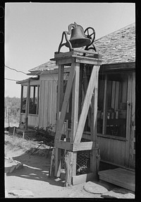 [Untitled photo, possibly related to: Bell on cattle Ranch near Spur, Texas. This is used to awake the cowboys in the morning, call them to the ranch house telephone, and announce meals] by Russell Lee