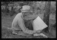 [Untitled photo, possibly related to: White migrant agricultural worker from Texas studying the map while stopped for lunch on the roadside east of Fort Gibson, Oklahoma] by Russell Lee