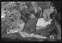 [Untitled photo, possibly related to: Migrant's car stopped along the road, with part of migrant family in rear seat of truck, under a tree to await the rain's passing, near Muskogee, Oklahoma] by Russell Lee