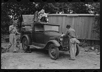 [Untitled photo, possibly related to: Migrant boy getting ready to crank his car, Muskogee, Oklahoma] by Russell Lee