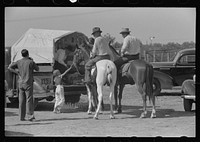 West Texans on their cow ponies buying soda pop at polo match, Abilene, Texas by Russell Lee