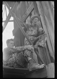 Roustabouts during a lull in painting of derrick. Seminole oil field, Oklahoma by Russell Lee