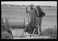 Cooperation in wells for irrigation purposes. Mr. Johnson and Mr. Wright, FSA (Farm Security Administration) clients, standing at the weir box, Syracuse, Kansas by Russell Lee