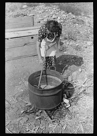 Spanish-American FSA (Farm Security Administration) client stirring kettle of soap, Taos County, New Mexico by Russell Lee