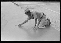 Smoothing concrete floor at migrant camp under construction at Sinton, Texas by Russell Lee