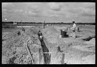 Laying sewer pipe at migrant camp under construction at Sinton, Texas by Russell Lee