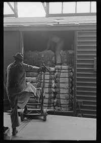 [Untitled photo, possibly related to: Unloading bale of cotton from freight car at cotton compress, Houston, Texas] by Russell Lee