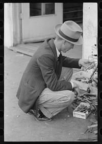 Man looking at wrench, market square, Waco, Texas by Russell Lee