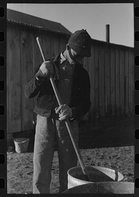 [Untitled photo, possibly related to: Son of Pomp Hall,  tenant farmer, carrying can full of mash to hogpen, Creek County, Oklahoma. See general caption, number 23] by Russell Lee