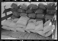 Stock salt and cotton seed meal on truck at warehouse of Kimble County, wool and mohair company. Junction, Texas by Russell Lee