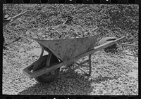 Wheelbarrow loaded with crushed rock to be used in bridge construction in Menard County, Texas by Russell Lee