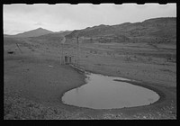 Stock waterhole and windmill, Socorro County, New Mexico by Russell Lee