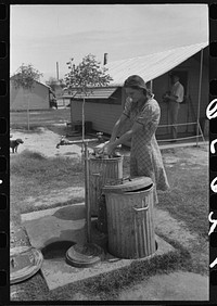 Garbage disposal and water supply at end of the row shelters in Agua Fria Migratory Labor Camp, Arizona by Russell Lee