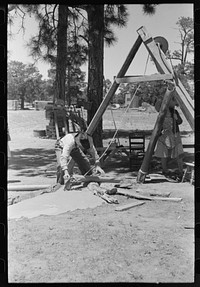 [Untitled photo, possibly related to: Farmer emptying slush from well which he is drilling with cable tools. Pie Town, New Mexico] by Russell Lee