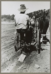 Faro Caudill planting beans. The block of wood dragging after the planter is a homemade contrivance for smoothing out soil after seeds have been planted. Pie Town, New Mexico by Russell Lee