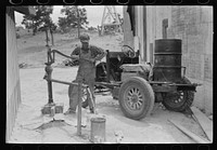 Homesteader pumping water which he will haul home from town. Wells require cash to drill and some farmers have not yet been able to drill their own wells. Pie Town, New Mexico by Russell Lee