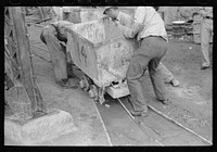 [Untitled photo, possibly related to: Moving ore car on narrow gage railroad track at gold mine, Mogollon, New Mexico] by Russell Lee