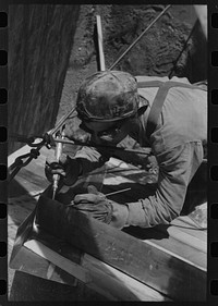 [Untitled photo, possibly related to: Spot welder at work on Shasta Dam. Shasta County, California] by Russell Lee