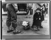 Los Angeles, California. The evacuation of Japanese-Americans from West Coast areas under U.S. Army war emergency order. Japanese-American child who is being evacuated with his parents to Owens Valley by Russell Lee