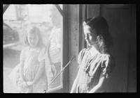 [Untitled photo, possibly related to: Two of the Dumond children at the back door of their home in Lille, Maine. French-Canadian potato farmers and FSA (Farm Security Administration) clients]. Sourced from the Library of Congress.