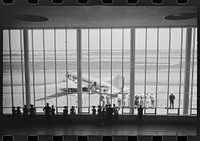 Visitors watching planes through the window of the main waiting room at the municipal airport in Washington, D.C.. Sourced from the Library of Congress.