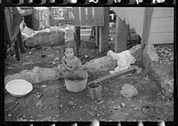 Little girl bathing on a street in a slum area in Yauco, Puerto Rico. Sourced from the Library of Congress.