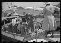 Buying produce at the waterfront in Christiansted. Most of the food comes in little schooners from Puerto Rico and the neighboring islands. Virgin Islands. Sourced from the Library of Congress.