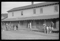 Company store, Saturday afternoon. At left, miners shooting craps; at right, card gambling, favorite pastime. Chaplin, West Virginia. Sourced from the Library of Congress.