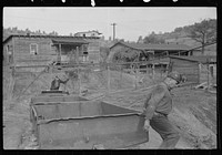 Miner lifting coal car on to track. Company houses in background. Chaplin, West Virginia by Marion Post Wolcott