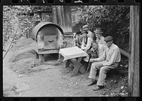 Bohemian miners (coal loaders) unemployed since mechanization of mines. Jere, West Virginia. They live together in one house with a woman housekeeper. All on relief. Spend most of their time fighting about politics. Call their dog "Hitler" because he's so mean and nasty. To the left is an outdoor oven for baking bread. Abandoned mining town. Sourced from the Library of Congress.