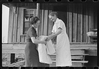 Miss Hesterley, FSA (Farm Security Administration) supervisor, delivers sheeting to Mrs. A.L. Lanier on undeveloped government place. Coffee County, Alabama. Sourced from the Library of Congress.
