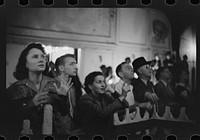 Coal miner's daughter, at left, and others at outdoor carnival watch man being shot from cannon, Granville, West Virginia. Sourced from the Library of Congress.