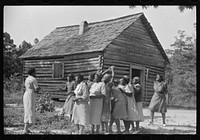 Juanita Coleman helps during recreation time for adult class. In the church she teaches them to read and write and to discuss any interests and problems. Gees Bend, Alabama. Sourced from the Library of Congress.
