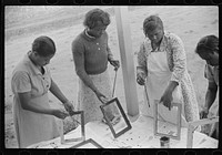 Home economics and home management class for adults under supervision of Evelyn M. Driver. Everything they make, including the hand looms, utilizes materials of local origin such as bamboo, cane, cornshucks, flour and meal and feed sacks, etc. Flint River Farms, Georgia. Sourced from the Library of Congress.