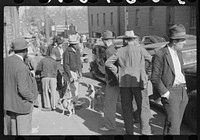 [Untitled photo, possibly related to: Farmer selling hound dogs outside tobacco warehouse during auction sales, Durham, North Carolina]. Sourced from the Library of Congress.