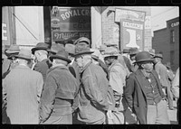 Spectators listening to patent medicine salesman who has his stand outside tobacco warehouse during tobacco auction sales. Durham, North Carolina. Sourced from the Library of Congress.