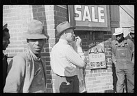 [Untitled photo, possibly related to: Patent medicine salesman demonstrating his wares to farmers outside warehouse during tobacco auction sale. Durham, North Carolina]. Sourced from the Library of Congress.