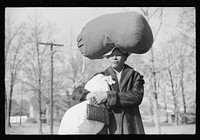 [Untitled photo, possibly related to: Woman carrying laundry home along highway between Durham and Mebane, North Carolina] by Marion Post Wolcott