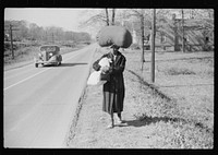  woman carrying laundry home along highway between Durham and Mebane, North Carolina. Sourced from the Library of Congress.