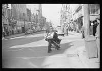 [Untitled photo, possibly related to: Tobacco auctioneer who "bet on Carolina" and lost, pays off the wager by pushing the warehouseman in a wheelbarrow from the warehouse to the courthouse. Durham, North Carolina]. Sourced from the Library of Congress.