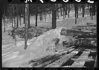 Logs hauled by tractor to the road where they are picked up by truck and taken to the mill. Near Barnard, Windsor County, Vermont. Sourced from the Library of Congress.