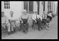 Townspeople visiting while sitting in front of Old Talbott Tavern on Saturday afternoon. Bardstown, Kentucky. Sourced from the Library of Congress.